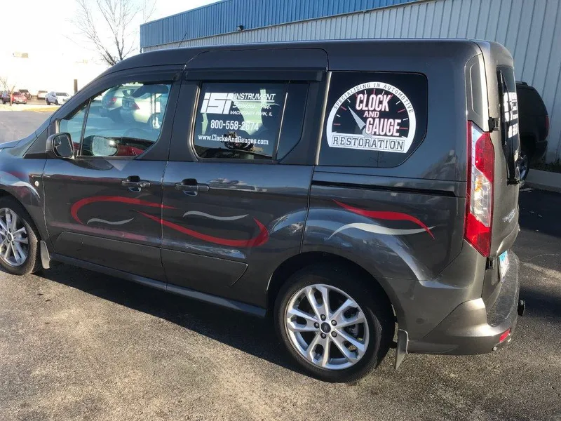 Gray Ford Transit Connect with red swoosh accents and window decals for ISI Instrument Services and Clock & Gauge Restoration.