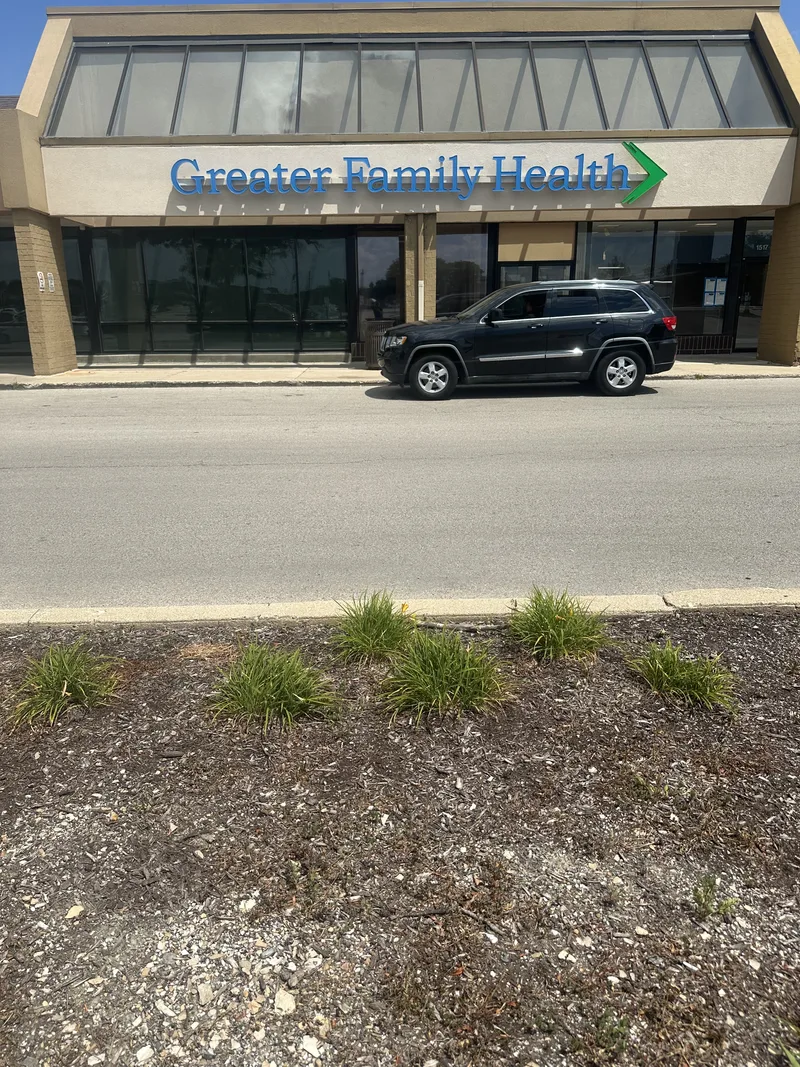 Greater Family Health storefront — blue branded fascia panel reading 'Greater Family Health' above clinic windows in a strip retail center.