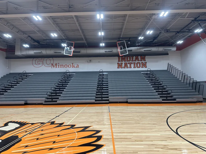 Minooka gym bleacher wall — "GO Minooka" and "INDIAN NATION" dimensional graphics above retractable bleachers, with the center-court logo in the foreground.