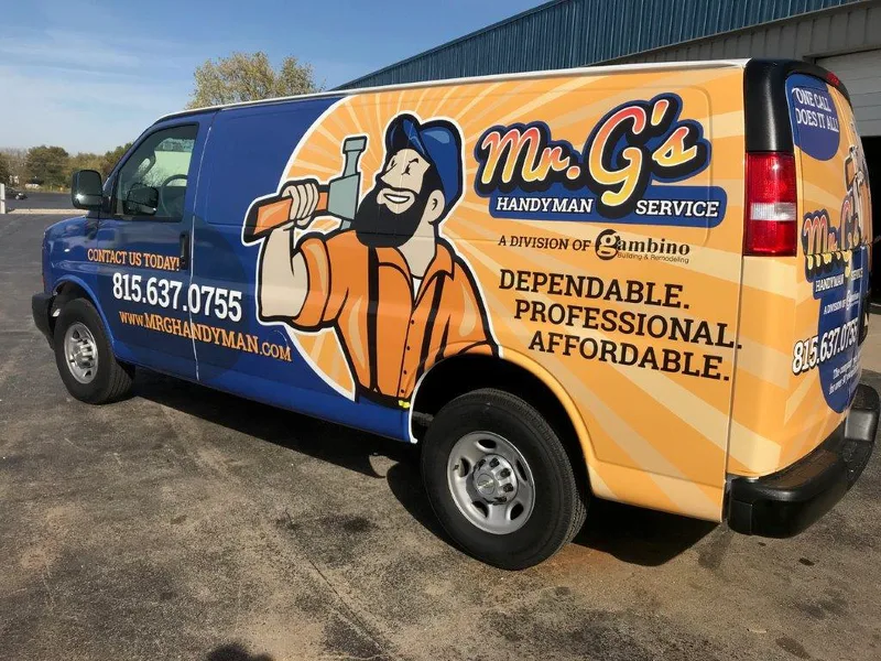 Mr. G's Handyman Service Chevy Express van — outdoor three-quarter rear view of a full-wrap with orange sunburst, cartoon handyman mascot with a wrench, 'Mr. G's Handyman Service — A Division of Gambino Building & Remodeling', 'Dependable. Professional. Affordable.', local Rockford 815 phone number, and 'One Call Does It All!' rear-window callout.