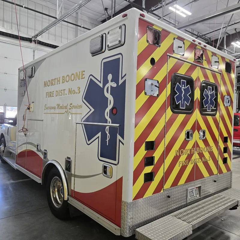 North Boone Fire District 3 ambulance — reflective red-and-yellow chevron rear graphics, blue Star of Life, and gold-leaf-style district lettering.