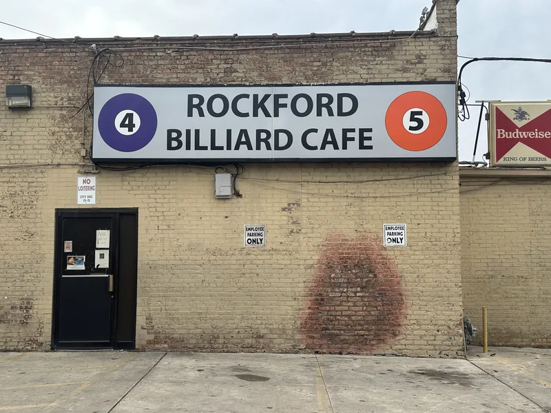 Rockford Billiard Cafe wall sign — white cabinet with "ROCKFORD BILLIARD CAFE" flanked by 4 and 5 pool-ball graphics on a painted brick building.