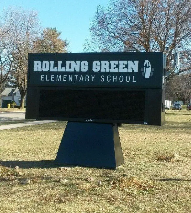 Rolling Green Elementary School monument — black cabinet with white lettering and an LED message board on a tapered pedestal base.