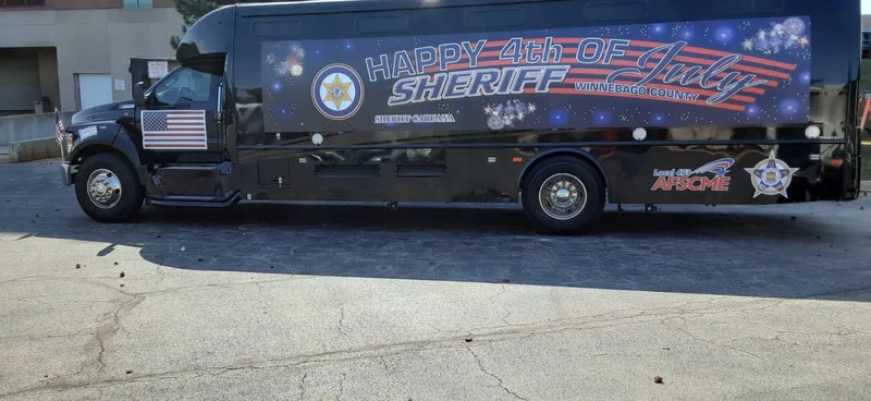 Winnebago County Sheriff transport coach — opposite side view of the patriotic 4th of July vehicle wrap.