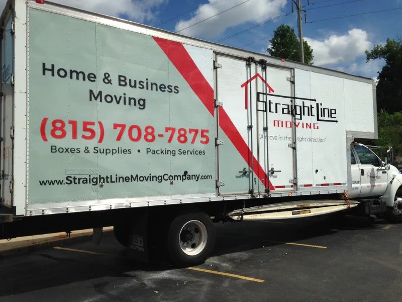 Straight Line Moving box truck — sage-green side wrap with a red diagonal stripe, "Home & Business Moving", phone number, and the Straight Line Moving house logo.