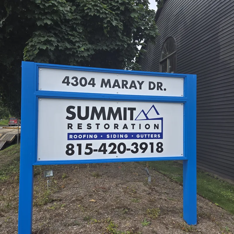 AFTER: Summit Restoration post-and-panel sign — refinished blue frame with new white "4304 MARAY DR." address and Summit Restoration roofing-siding-gutters panels.