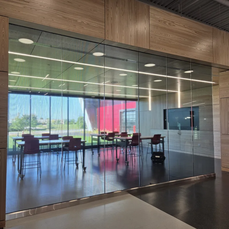 Waubonsee Community College Technical Education Center — striped decorative privacy film on a full-height glass conference-room wall.