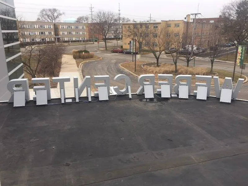 Webber Center channel letters staged on a rooftop in reverse — fabricated letters awaiting install above a campus parking lot.