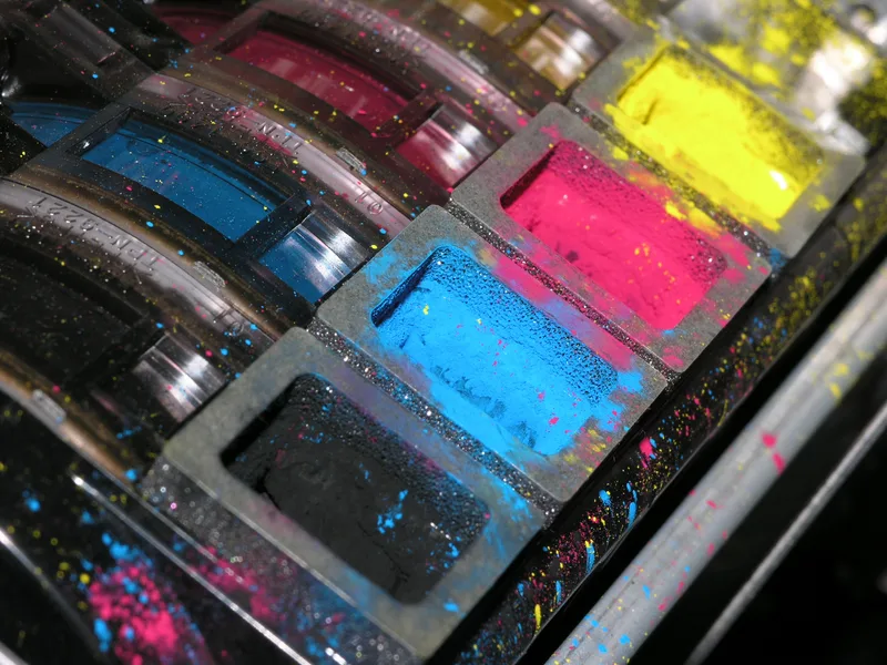 Close-up of CMYK printer ink wells — a glimpse of our in-house wide-format production.
